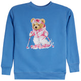 A blue crewneck sweatshirt featuring a central graphic of a cartoon teddy bear wearing a pink and white ski suit, goggles, and holding ski poles.