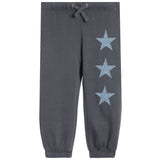 Dark gray jogger pants with three light blue denim star patches arranged vertically on the left leg, featuring an elastic waistband with a drawstring and elastic cuffs.