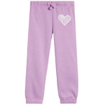 A pair of kids' sweatpants in light purple, featuring an embroidered white heart on the upper left leg and elastic cuffs at the ankles.