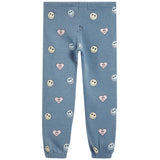 Light blue jogger pants with an all-over pattern of smiley faces and pink hearts, shown flat against a white background.