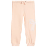 Light peach pink sweatpants with an elastic waistband, drawstring, and a white embroidered bow on the left leg, shown against a plain white background.
