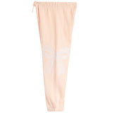 Light peach pink jogger pants featuring a white embroidered bow design on the left leg, with an elastic waistband and drawstring.