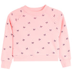 A light pink long-sleeve crewneck sweatshirt for toddlers, featuring an all-over pattern of small black bows, shown flat on a white background.