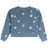 A kids' long-sleeve crewneck sweatshirt in heathered dusty blue, decorated with an all-over pattern of smiley faces, hearts, and bows in pastel colors, shown flat on a white background.