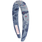 A wide fabric headband in a blue and gray tie-dye pattern, embellished with small pink rhinestones.