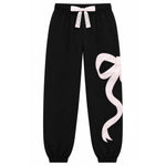 black jogger pants that have a large white ribbon graphic on the leg. 