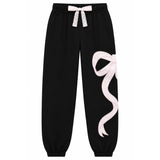 black jogger pants that have a large white ribbon graphic on the leg. 