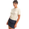 A woman modeling a short-sleeve cream knit sweater set against a plain white background.