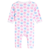 A baby long-sleeve footless one-piece romper with an all-over pink and blue smiley face pattern on a white background.