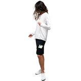 A woman modeling a white long-sleeve t-shirt and black athletic shorts with a white graphic logo, set against a plain white background.