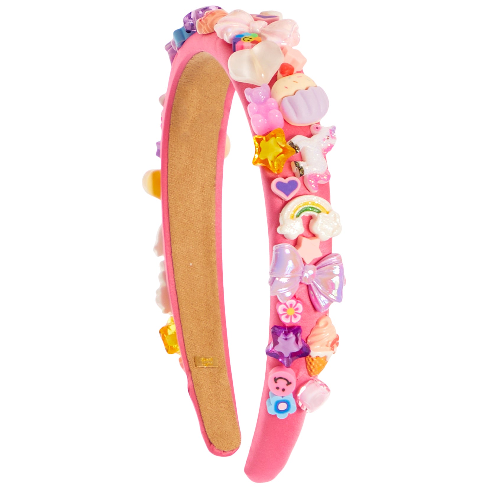 A pink headband decorated with colorful, whimsical charms including a rainbow, unicorn, cupcakes, stars, and bows, shown against a plain white background.