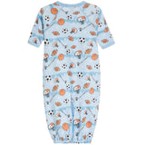 A baby long-sleeve footless onesie in light blue, featuring an all-over sports-themed print with basketballs, soccer balls, footballs, and referees on a white background.