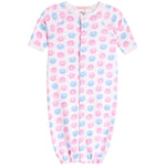 A baby long-sleeve footless sleeper with an all-over pink and blue smiley face pattern, featuring a snap-button front closure and elastic cuffs.