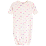 A baby sleep sack in cream with an all-over pattern of small pink and purple hearts, featuring short raglan sleeves and a front snap closure.