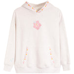 A light heathered off-white hooded sweatshirt featuring a pink hibiscus flower graphic on the chest, decorative pink, orange, and yellow dots along the hood trim and pocket openings, and a small light blue floral detail on the right sleeve.