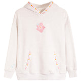 A light heathered off-white hooded sweatshirt featuring a pink hibiscus flower graphic on the chest, decorative pink, orange, and yellow dots along the hood trim and pocket openings, and a small light blue floral detail on the right sleeve.
