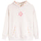 A light heathered off-white hooded sweatshirt featuring a pink hibiscus flower graphic on the chest, decorative pink, orange, and yellow dots along the hood trim and pocket openings, and a small light blue floral detail on the right sleeve.