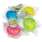 Four packaged coconut-shaped squishy toys in blue, yellow, green, and pink, each sealed in clear plastic packaging with a round cartoon tag that reads 'Coconut Oil Squishy'.