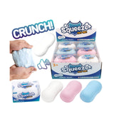 SqueeZo 'Try Me!' 3-in-1 stress relief toy set, featuring a multi-pack display box, individual packs, and three sample bars (white, pink, and blue) shown with hands demonstrating the squishy texture.