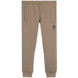 A pair of beige jogger sweatpants with a small black graphic of a face wearing sunglasses on the left thigh, shown against a plain white background.