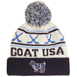 A cream knit beanie with a navy and blue pom-pom, featuring the text 'GOAT USA' and a goat mascot graphic on a navy ribbed cuff.