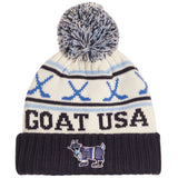 A cream knit beanie with a navy and blue pom-pom, featuring the text 'GOAT USA' and a goat mascot graphic on a navy ribbed cuff.