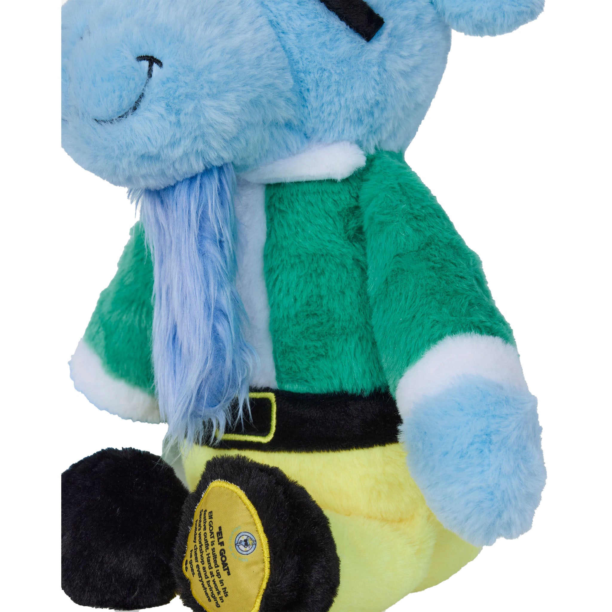 A plush toy goat with fluffy light blue fur, wearing a green top with white trim, a black belt, and yellow pants, shown against a plain white background.