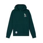 A dark green pullover hoodie with a small embroidered character under a Christmas tree on the left chest and a circular patch on the front pocket, shown against a plain white background.