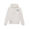 An off-white pullover hoodie with a small green graphic on the left chest and a circular patch on the lower front pocket, displayed against a solid white background.