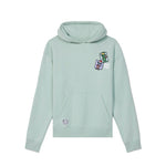 A light mint green pullover hoodie with a kangaroo pocket, featuring a small colorful graphic on the left chest and a circular logo patch on the lower left front, displayed against a solid white background.