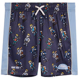 A pair of kids' athletic shorts featuring a navy blue base with an all-over print of cartoon soccer players wearing gold crowns. The shorts have light blue side panels with white piping, a white drawstring, and 'GOAT USA' branding on the lower left leg.