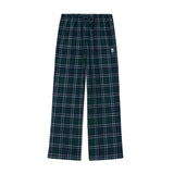 A pair of wide-leg plaid lounge pants in dark green with white and light blue lines, featuring an elastic waistband and a small white embroidered logo on the left thigh.
