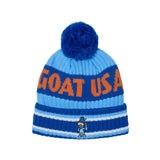 A blue and light blue knit beanie hat with a dark blue pom-pom, featuring the text 'GOAT USA' in orange and a small goat mascot logo near the cuff.