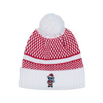 A red and white knit beanie hat with a white pom-pom on top and a white ribbed cuff, featuring a small embroidered goat Santa Claus character on the front.