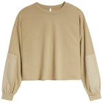 A cropped long-sleeve sweatshirt in a warm tan/beige color, featuring solid fabric on the body and contrasting slightly lighter beige patch pockets on the sleeves, shown against a plain white background.