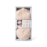 A packaged fluffy cream-colored heated eye mask, shown inside its light gray cardboard box with a paper band label.