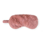 A dusty pink faux fur sleep mask with an integrated elastic strap, shown from a side profile view against a solid white background.
