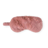 A dusty pink faux fur sleep mask with an integrated elastic strap, shown from a side profile view against a solid white background.
