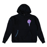 A black pullover hoodie with a colorful pink and blue graphic on the left chest resembling a stylized character or mask, set against a plain white background.