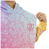 A close-up of a person wearing a hooded sweatshirt with a pastel gradient and sprinkle pattern. The hoodie transitions from light blue at the top to pink at the bottom, covered in pink and white sprinkle shapes.