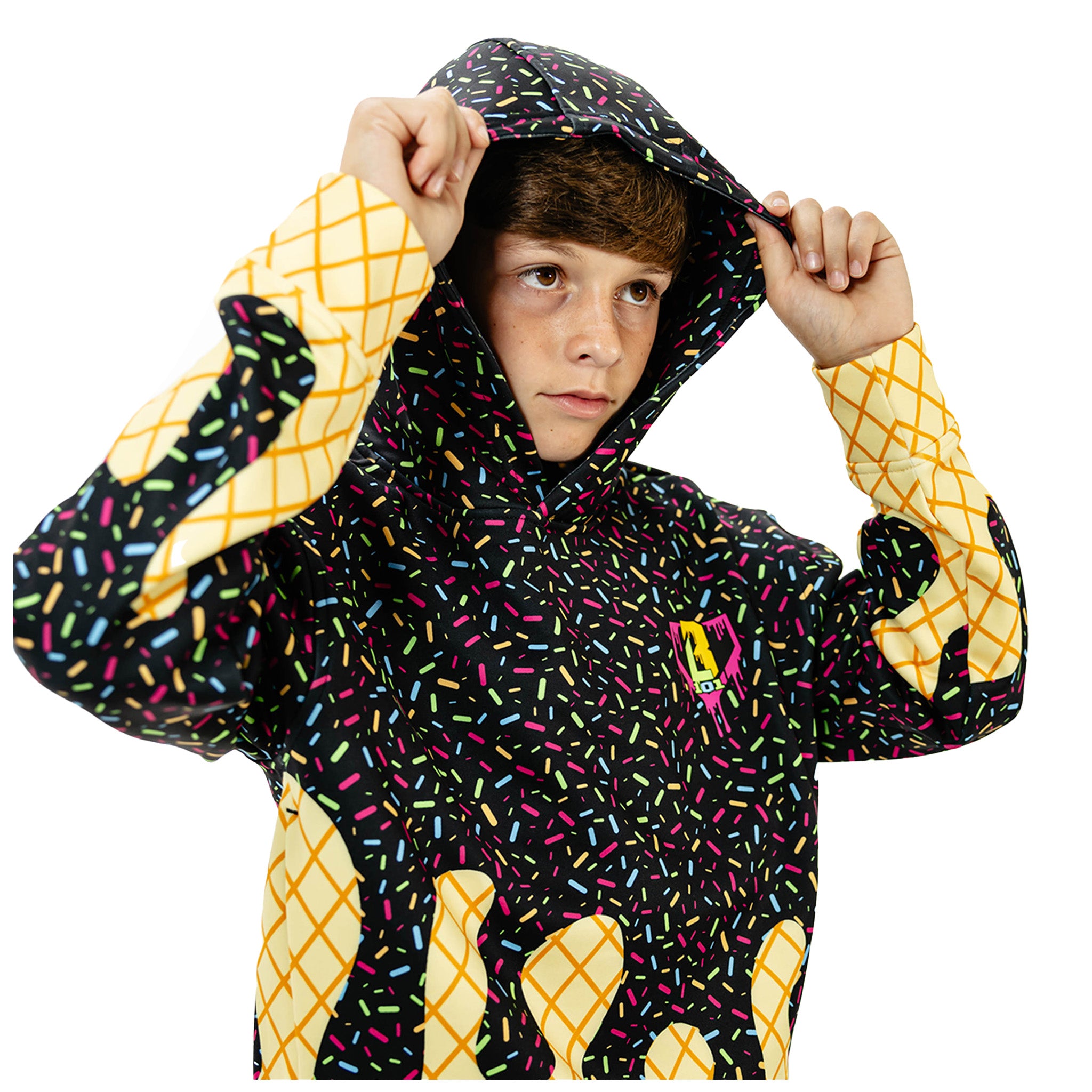 A child wearing a hooded jacket with a black background covered in multicolored sprinkles, yellow diamond-patterned cuffs and lower sleeves, and a small pink-and-yellow chest graphic, posed against a plain white background.