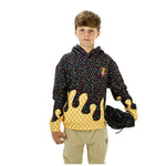 A young boy modeling a black hoodie with a colorful sprinkle pattern and a yellow dripping ice cream design on the lower front, paired with khaki pants and holding a black baseball glove.