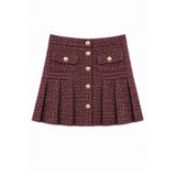 A pleated tweed mini skirt in a dark burgundy and brown woven pattern, featuring a button-up front with gold-tone buttons and two decorative button-flap pockets on the front.