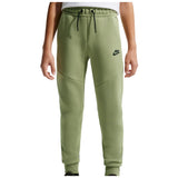 A person wearing sage green Nike sweatpants with a black drawstring and a black Nike logo on the left thigh, shown against a plain white background.