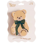 The Darling Effect 1 shape claw clip in the form of a teddy bear, packaged on a white scalloped backing card. The bear is light tan with a dark green bow around its neck.