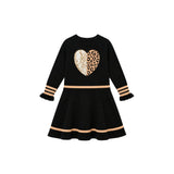 A black long-sleeve children's dress with a leopard-print heart patch on the chest, beige stripes on the sleeves and hem, and ruffled cuffs, shown on a plain white background.