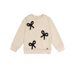 An off-white ribbed knit long-sleeve sweatshirt with three black bow appliqués on the front, displayed flat against a solid white background.