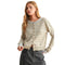 A woman modeling a cropped, long-sleeve knit cardigan with horizontal olive green and cream stripes, featuring brown buttons down the front against a solid white background.