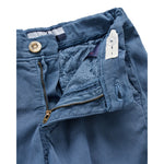 Close-up of a pair of blue shorts showing the waistband, button closure, zippered front pocket, and interior lining.