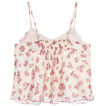 A white camisole top with a pink floral print, featuring thin adjustable straps and a smocked waist.